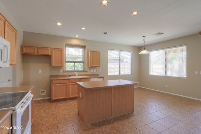 kitchen featuring light tile patterned flooring, a center island, decorative light fixtures, and sink