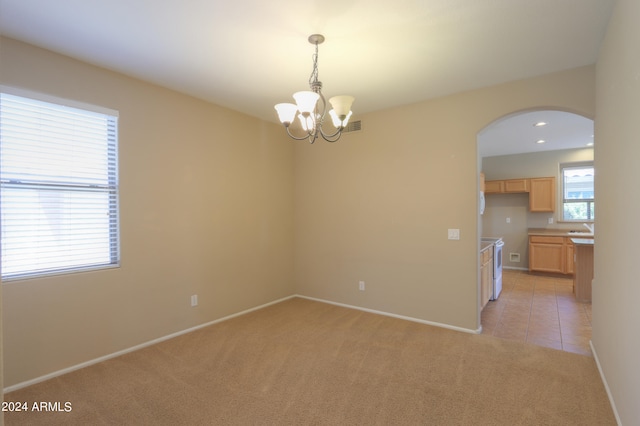 empty room featuring a notable chandelier, sink, and light carpet