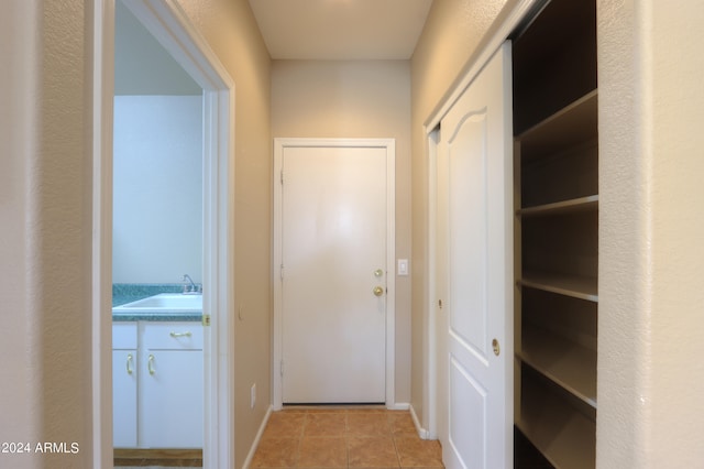 hallway with light tile patterned flooring and sink