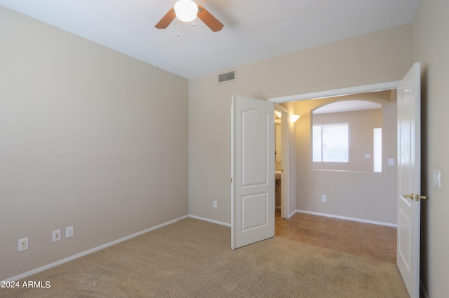 unfurnished bedroom featuring light carpet and ceiling fan