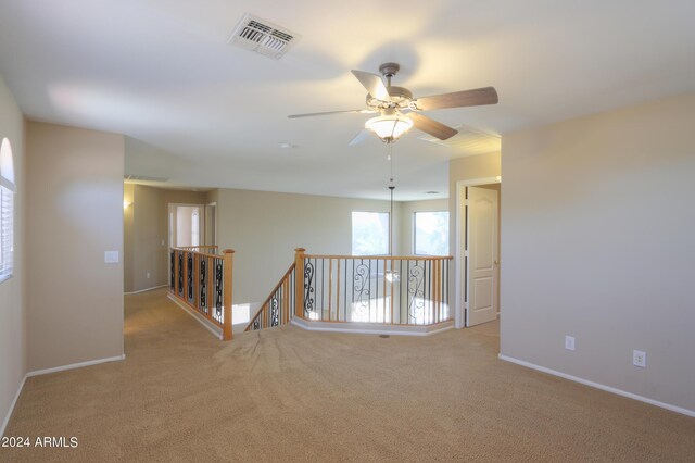 carpeted empty room featuring ceiling fan