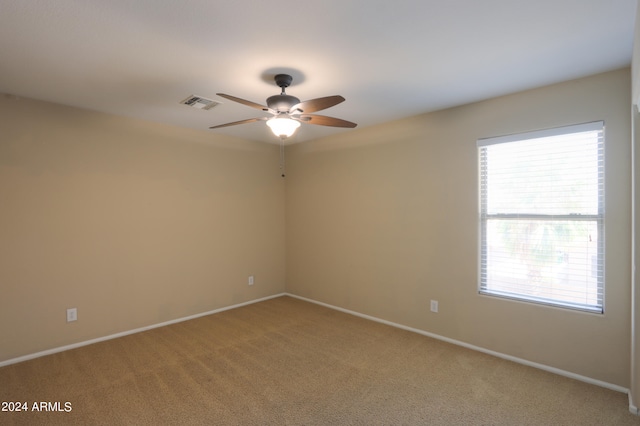 carpeted spare room with ceiling fan