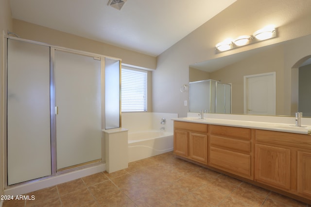 bathroom featuring tile patterned floors, vanity, shower with separate bathtub, and vaulted ceiling