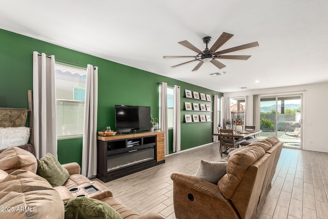 living room featuring ceiling fan and light hardwood / wood-style floors