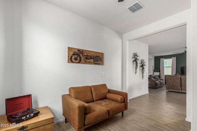 living area with light hardwood / wood-style flooring and ceiling fan