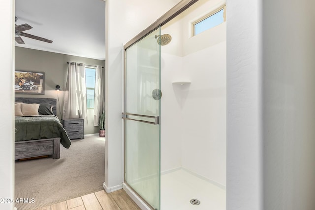 bathroom featuring hardwood / wood-style floors, an enclosed shower, and ceiling fan