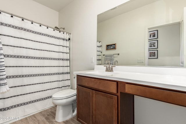 bathroom featuring wood-type flooring, toilet, and vanity