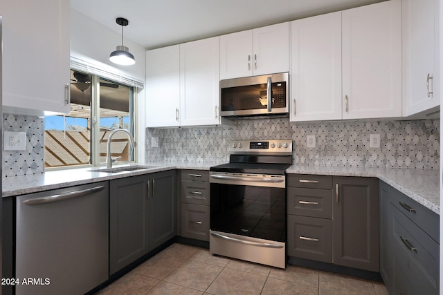 kitchen featuring light stone counters, sink, white cabinets, and stainless steel appliances