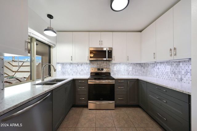 kitchen with white cabinets, pendant lighting, sink, and stainless steel appliances