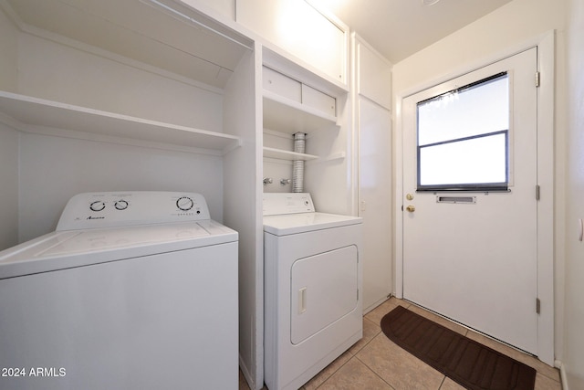 laundry area with washer and dryer and light tile patterned floors