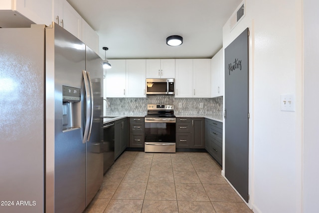 kitchen featuring gray cabinetry, white cabinetry, stainless steel appliances, pendant lighting, and light tile patterned floors