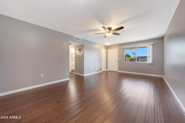 empty room with dark hardwood / wood-style flooring and ceiling fan