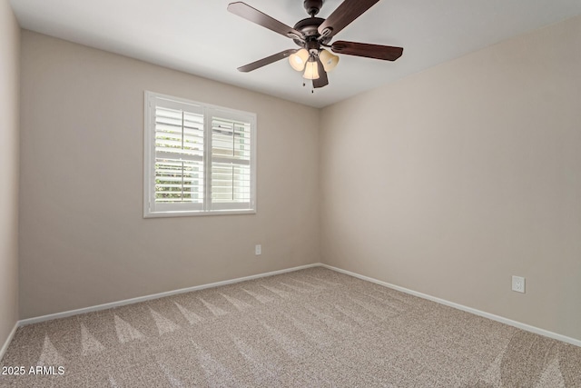 carpeted spare room with baseboards and a ceiling fan