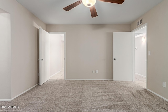 unfurnished bedroom featuring ceiling fan, visible vents, baseboards, and carpet