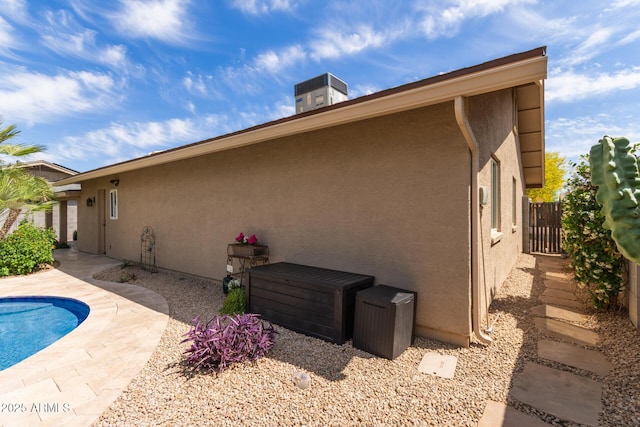 exterior space featuring a fenced in pool, fence, and stucco siding
