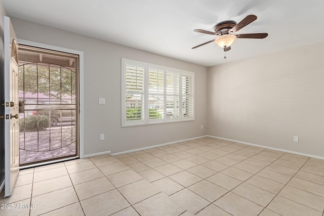 empty room with baseboards, a ceiling fan, and light tile patterned floors