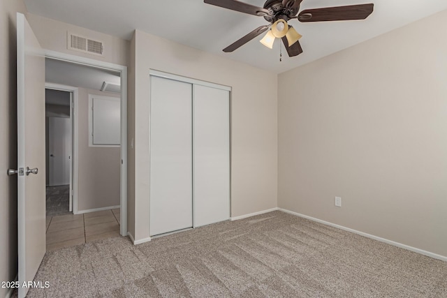 unfurnished bedroom featuring a ceiling fan, visible vents, baseboards, a closet, and carpet flooring