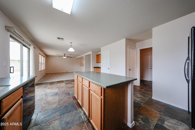 4804 S 25th Dr, Phoenix, AZ 85041 - kitchen featuring stone tile flooring, black appliances, a ceiling fan, open floor plan, and brown cabinetry