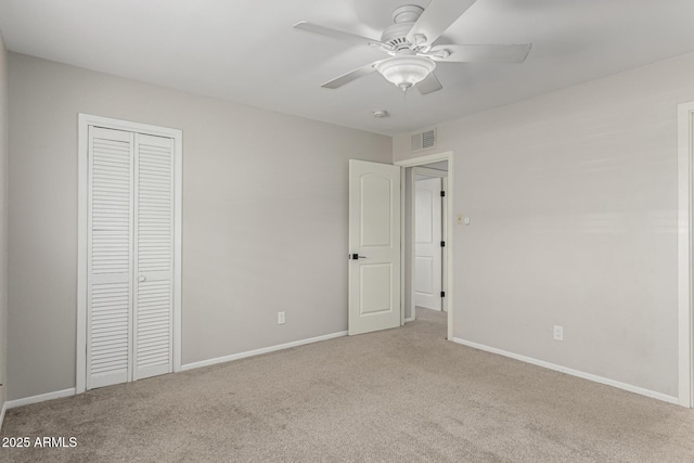 unfurnished bedroom featuring baseboards, visible vents, ceiling fan, carpet floors, and a closet