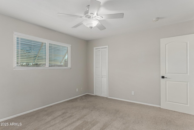 unfurnished bedroom featuring carpet floors, a closet, a ceiling fan, and baseboards