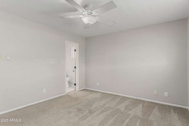 carpeted spare room with a ceiling fan and baseboards