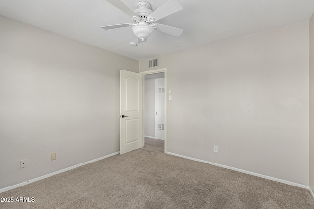 empty room featuring carpet, visible vents, and baseboards