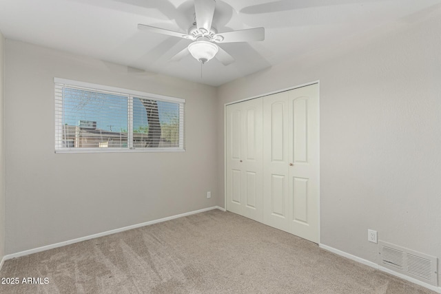 unfurnished bedroom featuring baseboards, visible vents, a ceiling fan, carpet, and a closet