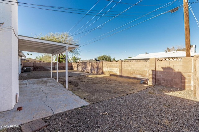 view of yard with a fenced backyard, a patio, and central AC unit