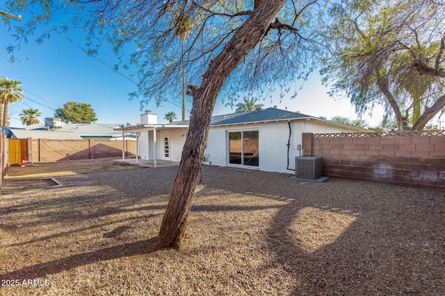 rear view of property featuring a fenced backyard, a patio, and central AC unit