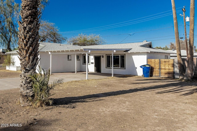 single story home with a patio, a shingled roof, and fence