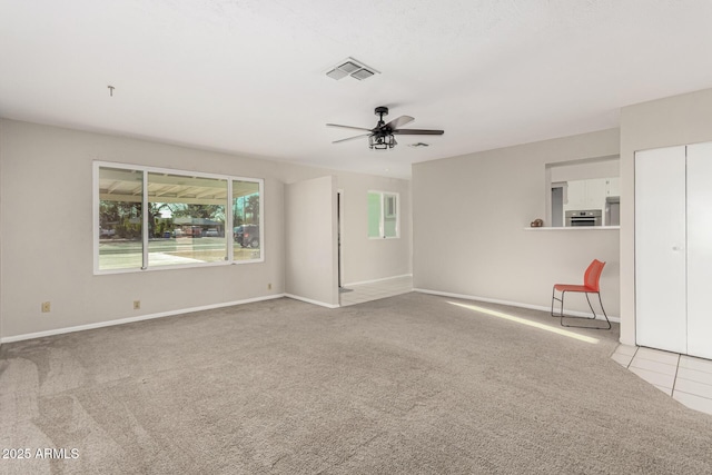 empty room with baseboards, visible vents, ceiling fan, and carpet flooring