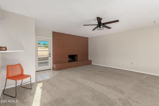 unfurnished living room featuring ceiling fan, tile patterned flooring, a fireplace, carpet flooring, and baseboards