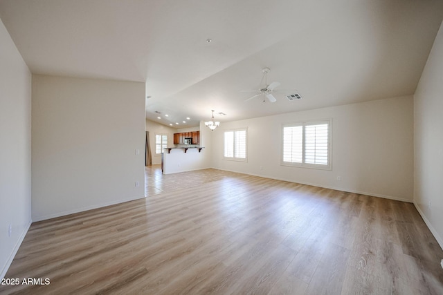 unfurnished living room featuring visible vents, lofted ceiling, baseboards, light wood-style floors, and ceiling fan with notable chandelier
