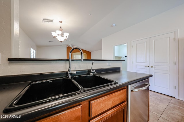kitchen featuring brown cabinetry, visible vents, stainless steel dishwasher, dark countertops, and a sink