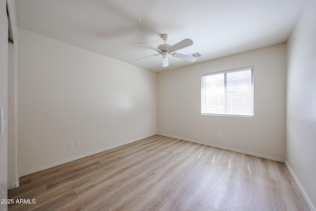 empty room with ceiling fan, visible vents, baseboards, and light wood-style floors