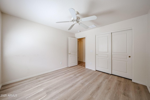 unfurnished bedroom featuring a closet, light wood finished floors, ceiling fan, and baseboards