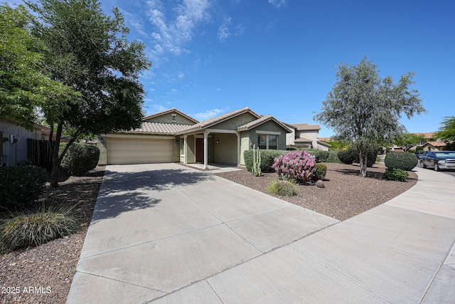 ranch-style house with a garage, stucco siding, a tiled roof, and concrete driveway