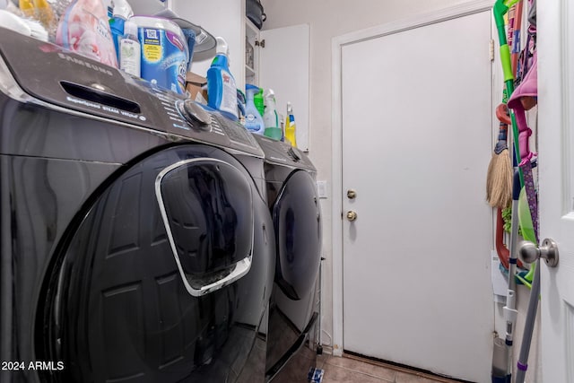 laundry area with washer and clothes dryer and light tile patterned floors