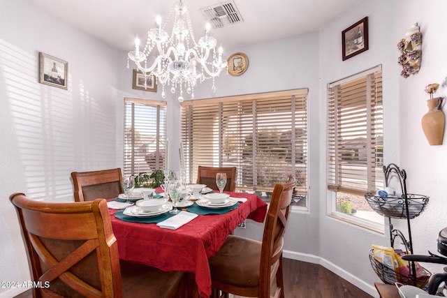 dining area with hardwood / wood-style flooring, plenty of natural light, and a notable chandelier