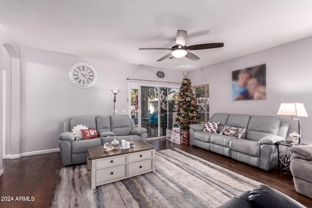 living room featuring a textured ceiling, dark hardwood / wood-style flooring, and ceiling fan