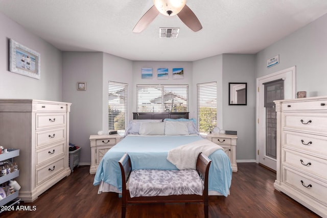 bedroom featuring ceiling fan, dark hardwood / wood-style floors, and a textured ceiling