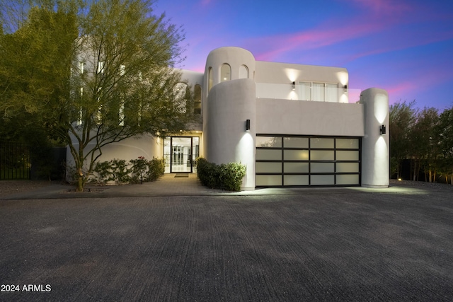 view of front of house with an attached garage, driveway, and stucco siding