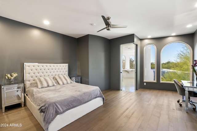 bedroom with light hardwood / wood-style floors, ensuite bath, and ceiling fan