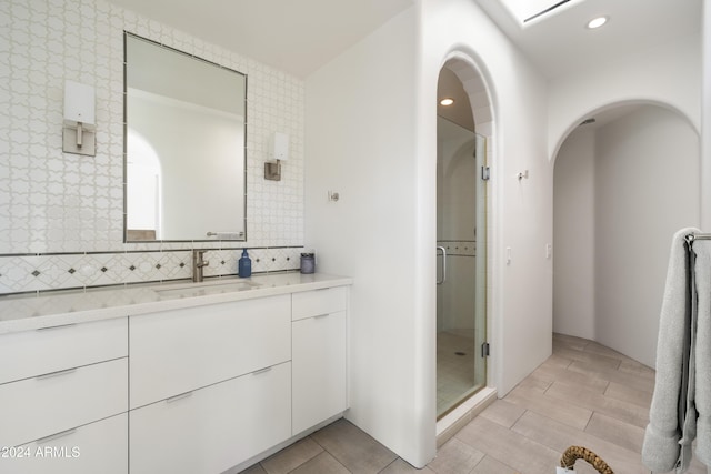 bathroom featuring vanity, an enclosed shower, and tile walls