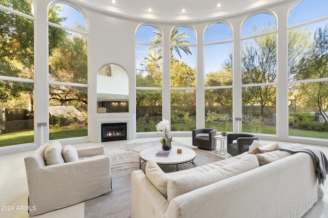 sunroom with a warm lit fireplace and a wealth of natural light