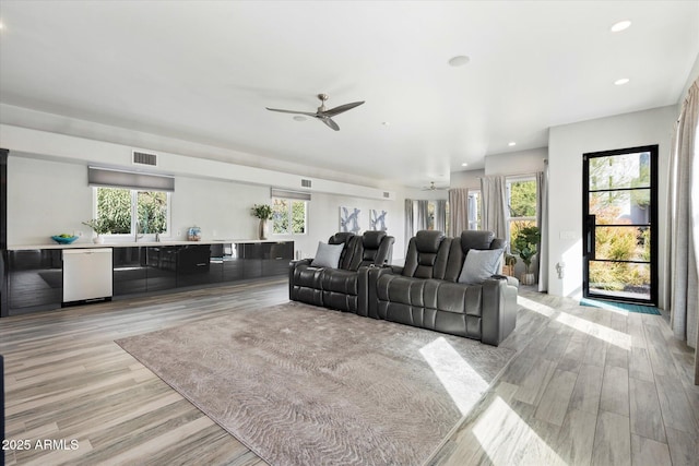 living room featuring light wood-type flooring, visible vents, and recessed lighting