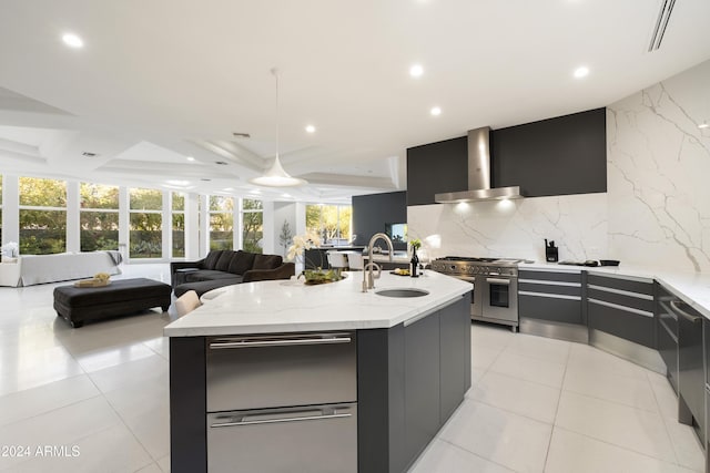 kitchen featuring a center island with sink, double oven range, wall chimney range hood, and sink