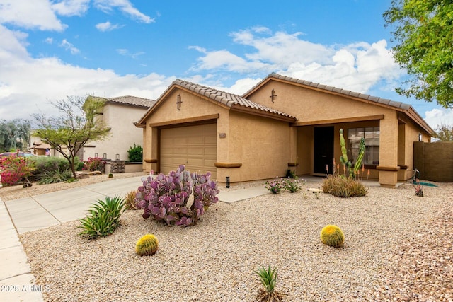 43142 N Outer Bank Dr, Anthem, AZ 85086 - mediterranean / spanish house featuring a tiled roof, driveway, stucco siding, and an attached garage