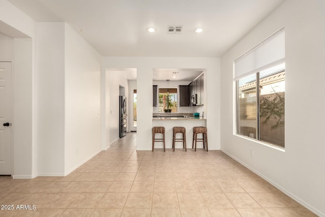 43142 N Outer Bank Dr, Anthem, AZ 85086 - kitchen with light countertops, visible vents, stainless steel appliances, a breakfast bar area, and light tile patterned floors