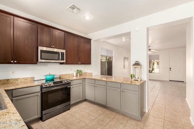 43142 N Outer Bank Dr, Anthem, AZ 85086 - kitchen with visible vents, ceiling fan, stainless steel appliances, dark brown cabinets, and light stone counters